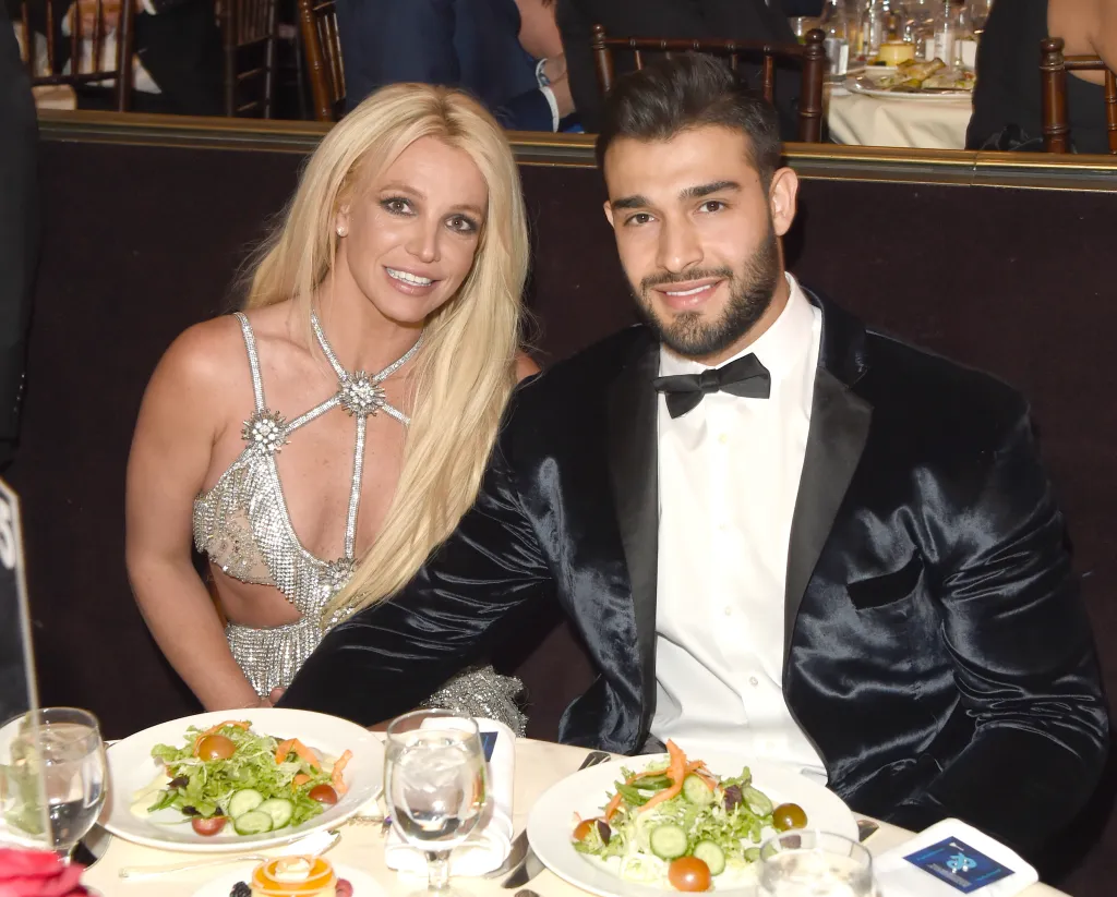Britney Spears and Sam Asghari seated at a formal event.
