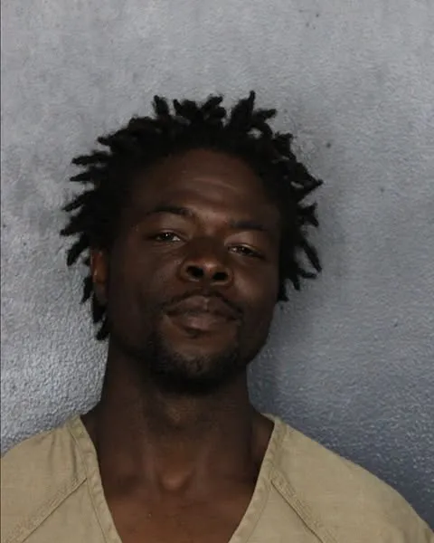 Mugshot of Samuel Prescott Lackey, a man with dreadlocks wearing a tan shirt.