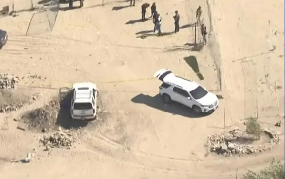 Aerial view of crime scene in Antelope Valley with white vehicles, police tape, and officers.