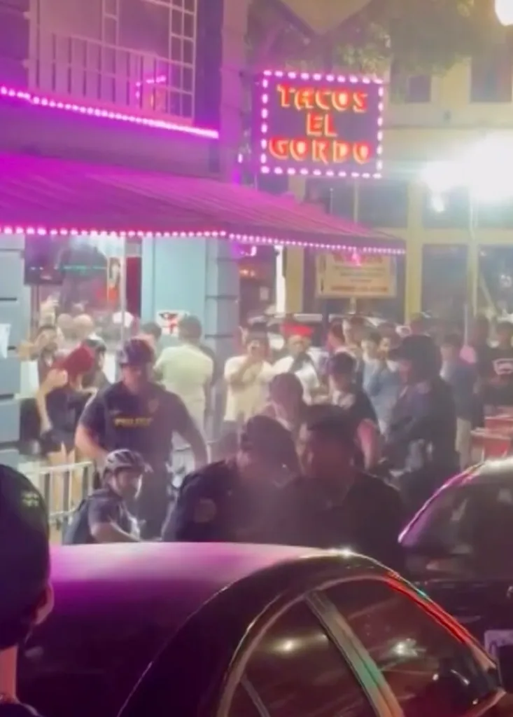 Police officers interacting with a crowd in front of a 