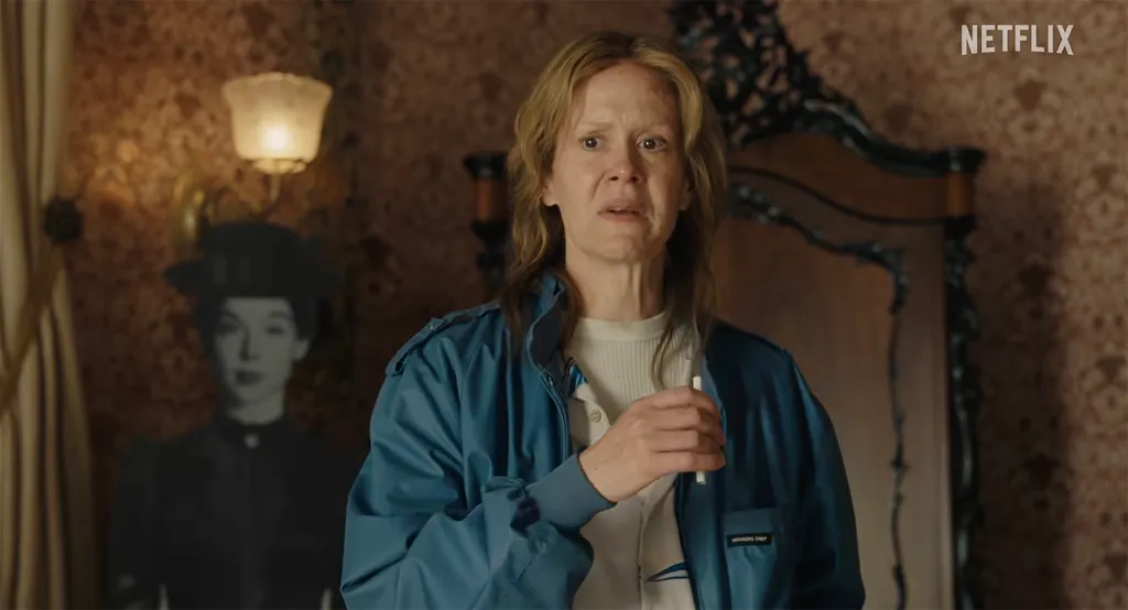 Sarah Paulson as serial killer Aileen Wuornos, wearing a blue jacket and holding a cigarette.