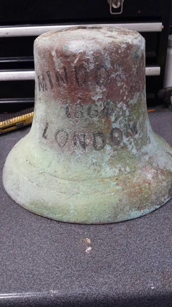The ship bell of The Mindoro, with “MINDORO 1864 LONDON” etched into its side.