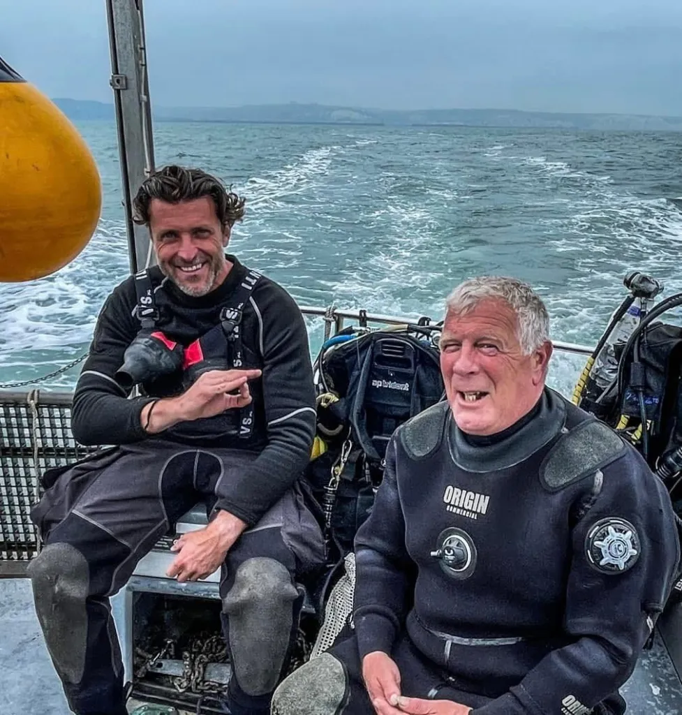 Divers Stefan Panis and Eddie Huzzie on a boat after discovering a bottle of Guinness.