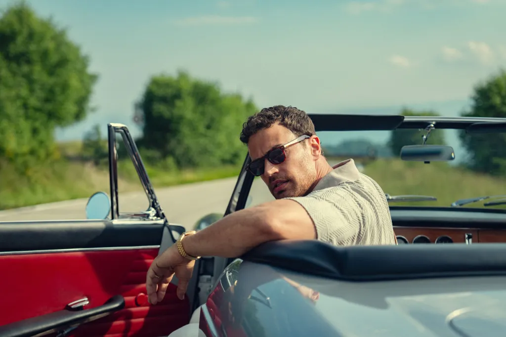 Theo James as James in a convertible car in 