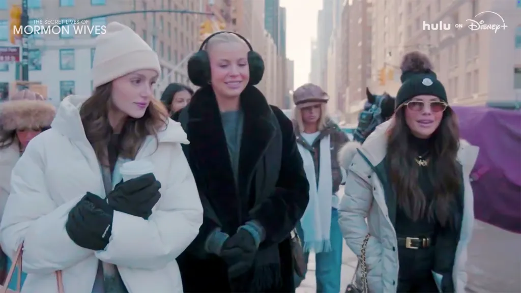 Women in winter attire walking outdoors, advertising 