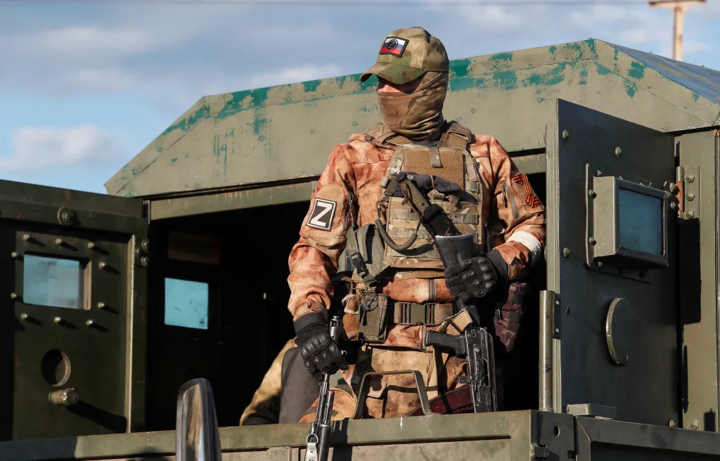 A service member of pro-Russian troops stands guard before the expected evacuation of wounded Ukrainian soldiers from the besieged Azovstal steel mill in the course of Ukraine-Russia conflict in Mariupol, Ukraine May 16, 2022. 