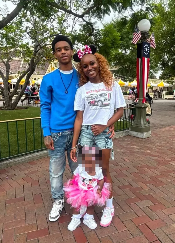 Levi Brown, standing next to a woman and a child, at a park.