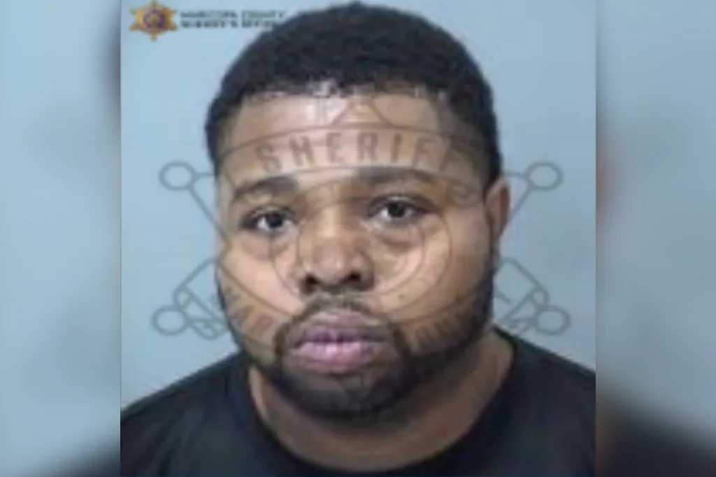 Mugshot of a Black man with a beard and short, dark hair.
