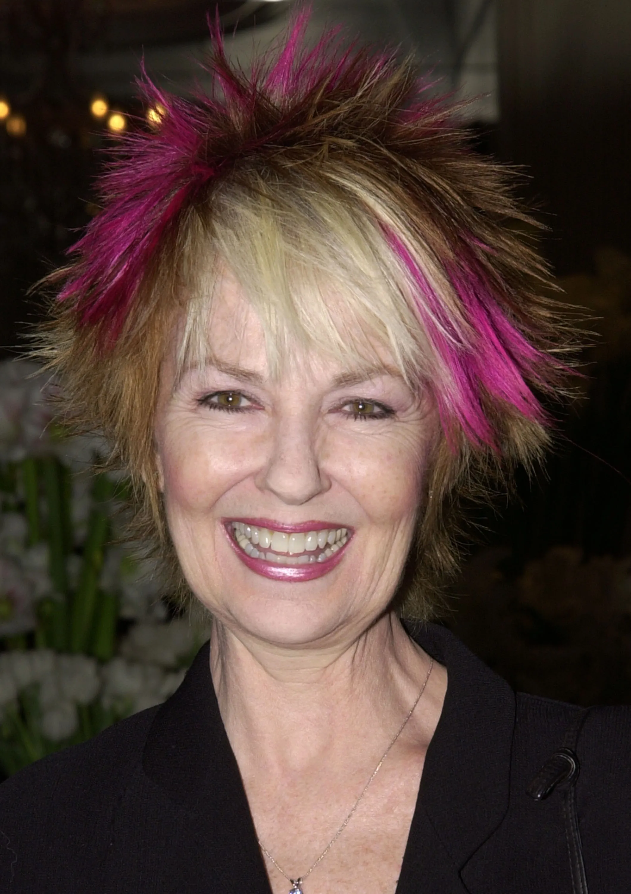 Shelley Fabares smiling while wearing a spiky hairstyle with pink and blonde highlights.