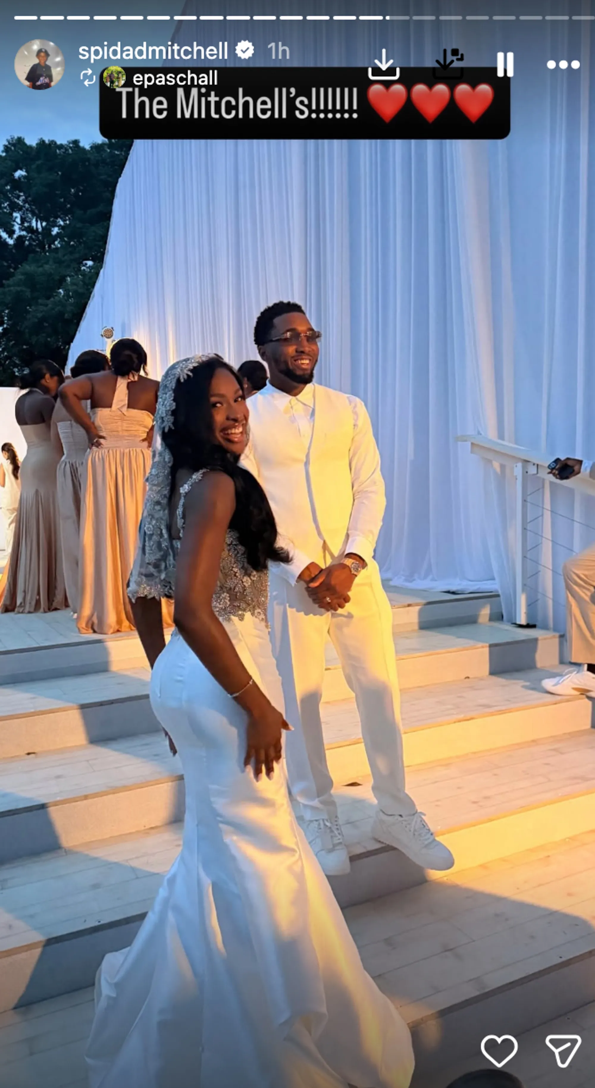 Singer Coco Jones in a white wedding gown, and NBA player Donovan Mitchell in a white suit, smiling at their wedding.
