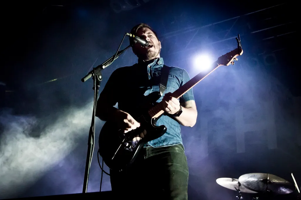 Singer Dustin Kensrue performing live on stage during a concert.