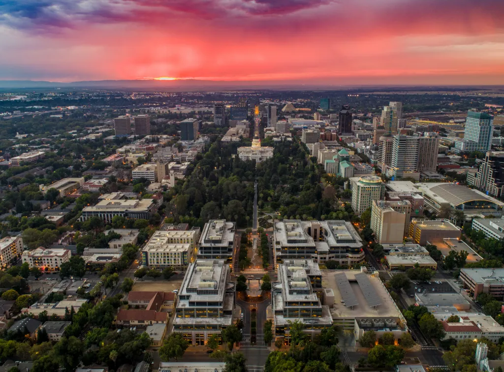 Aerial view of downtown Sacramento with a red and orange sunset.