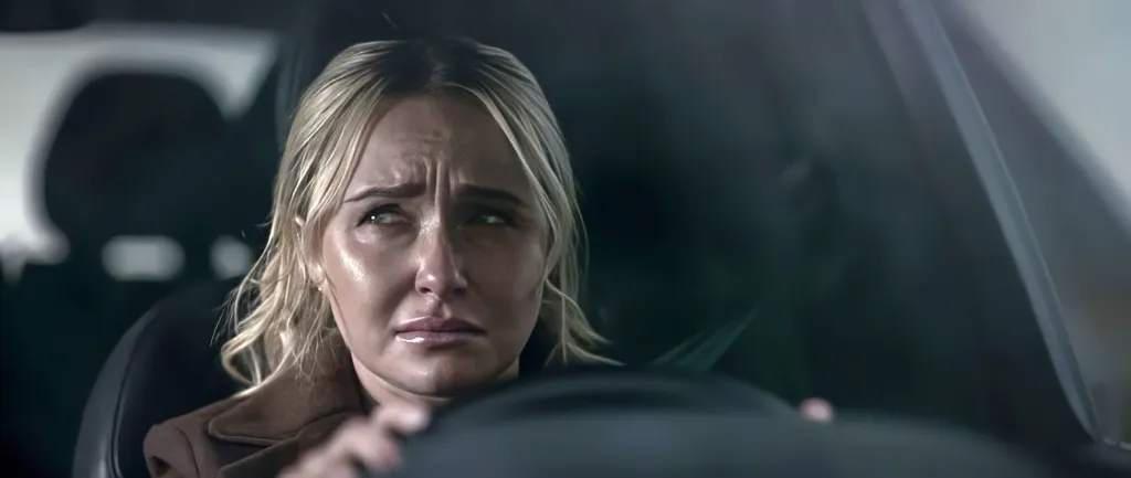 Hayden Panettiere in a car, looking distressed.