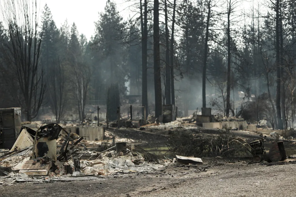 Smoke rises from burnt structures after a wildfire in a residential area of Westgate, Monday, Aug. 3, 2026, in Spokane, Wash.