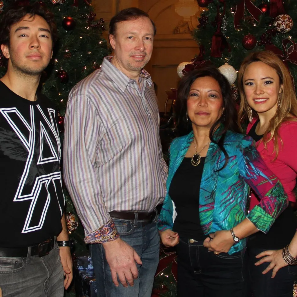 The Edwards family, including son Josh, Pastor Evan, wife Mary Jane, and daughter Joy, pose in front of Christmas trees.