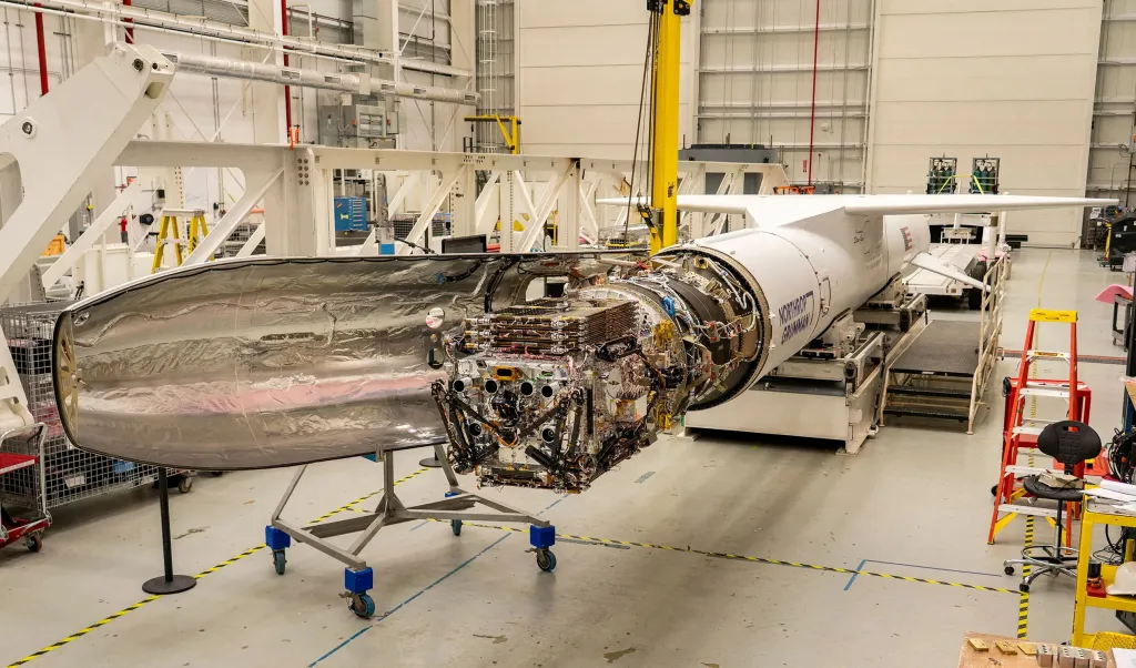 A spacecraft built by Katalyst Space next to a Northrop Grumman Pegasus XL rocket.