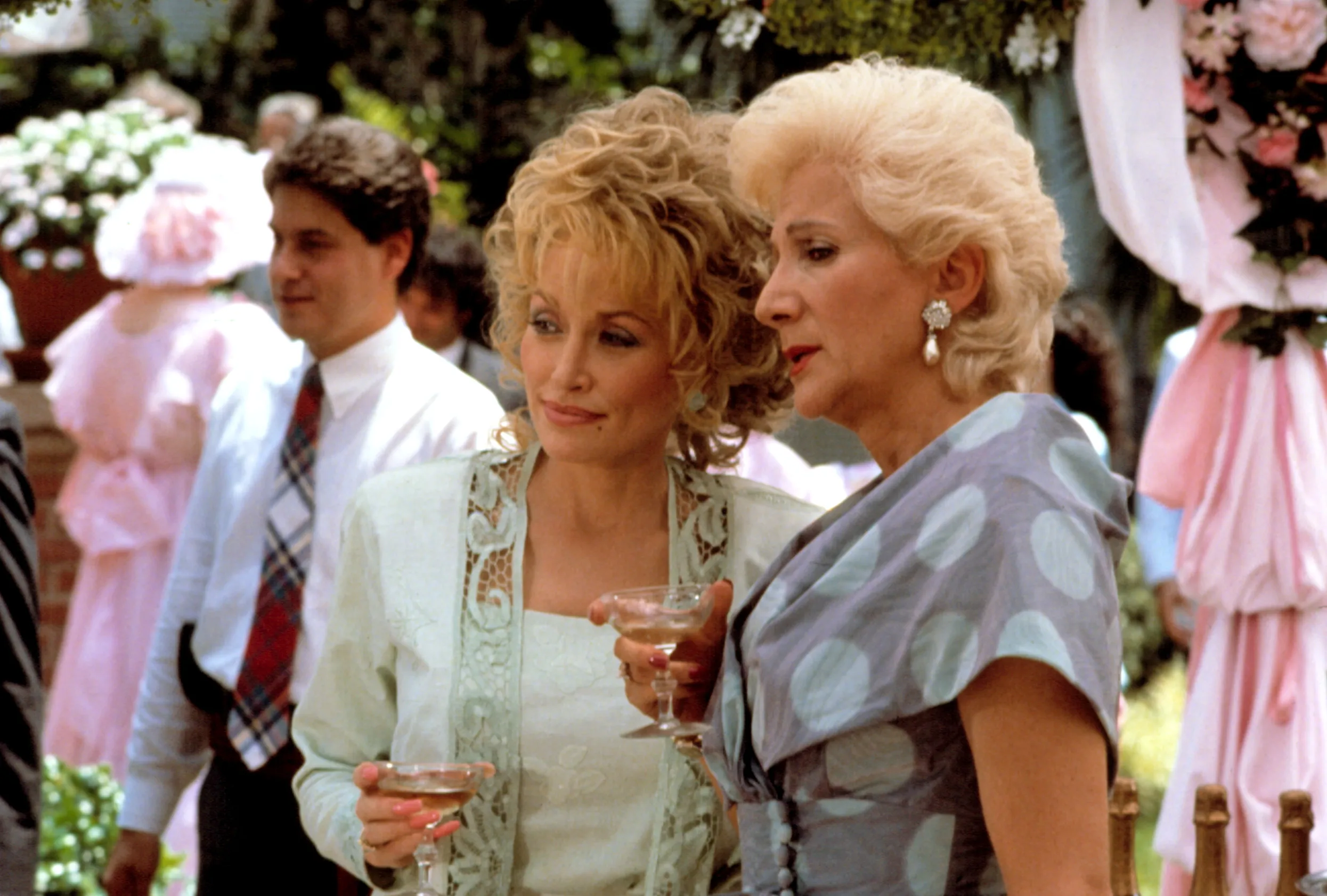 Dolly Parton and Olympia Dukakis holding champagne glasses in Steel Magnolias