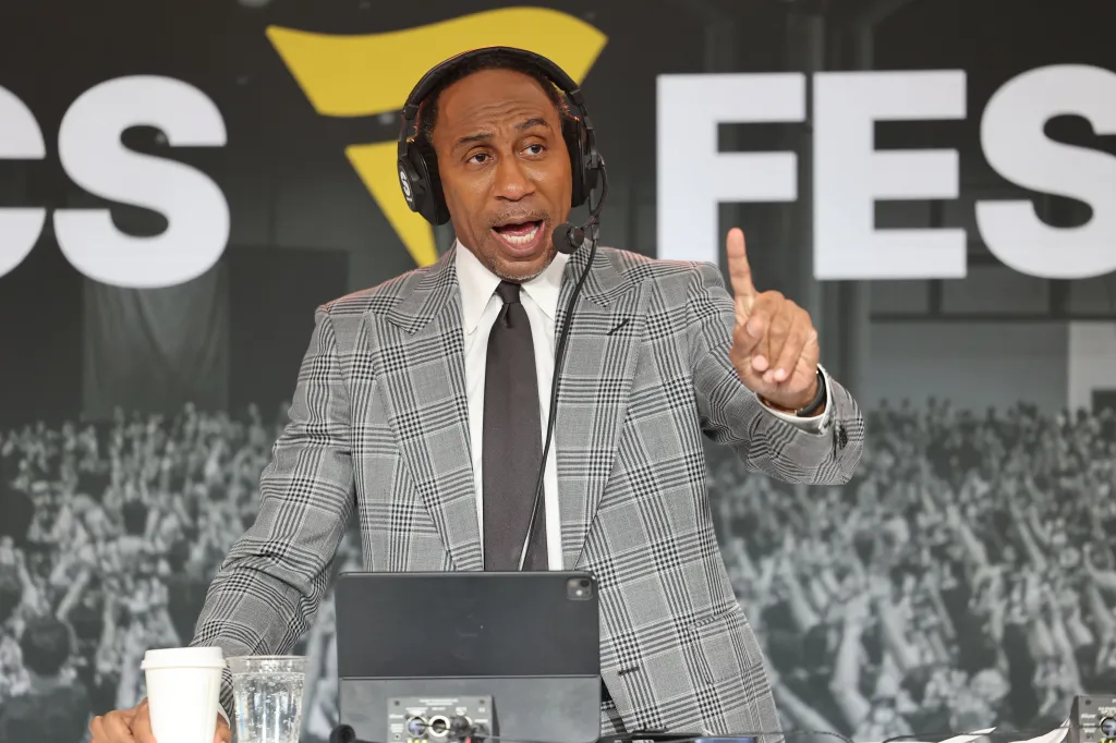 Stephen A. Smith speaking into a headset microphone, pointing his right index finger, at the 3rd Fanatics Fest NYC.