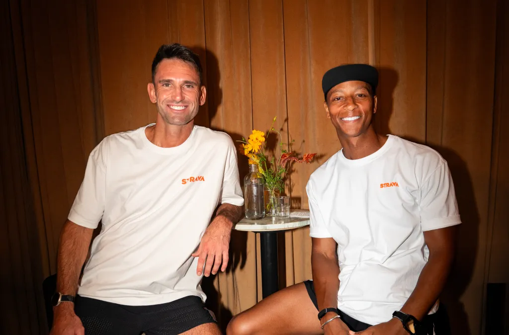 Two men, one white and one Black, smiling at the camera.