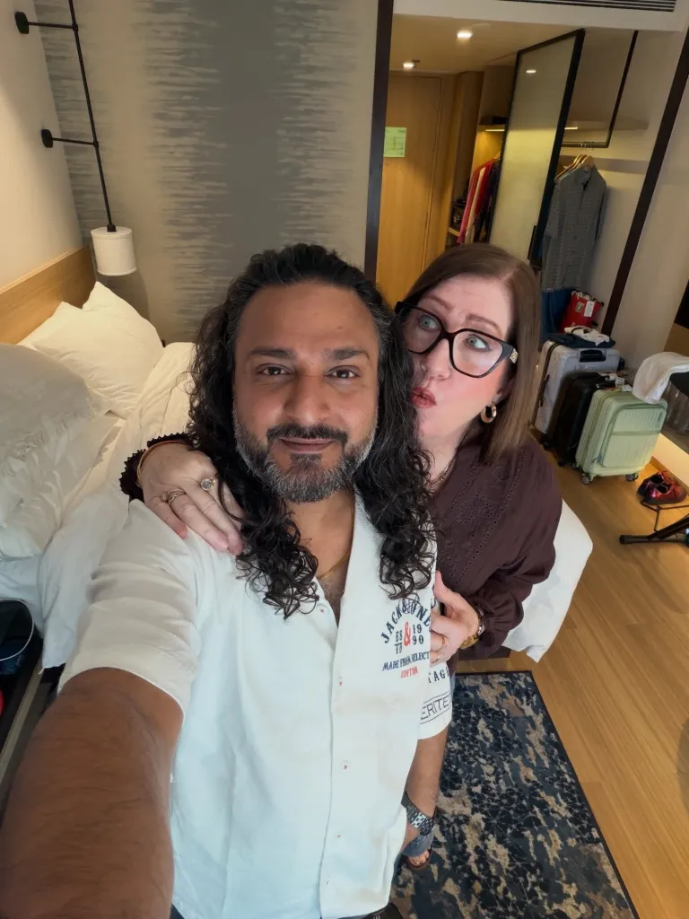 Sumit and Jenny from 90 Day Fiance pose together in a hotel room.