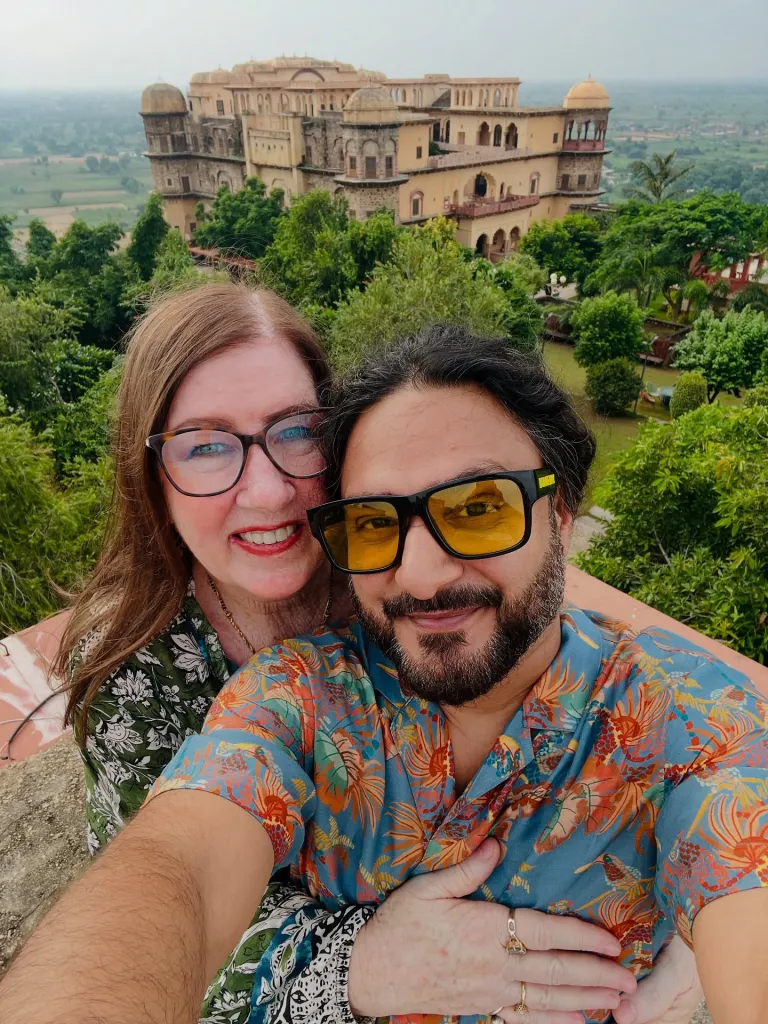 Sumit and Jenny from 90 Day Fiance taking a selfie with a historic building in the background.