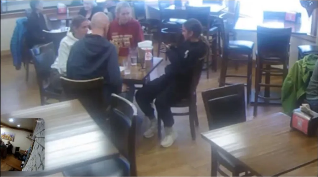 CCTV footage of four people sitting at a table in Sweet Zoey Mediterranean restaurant.
