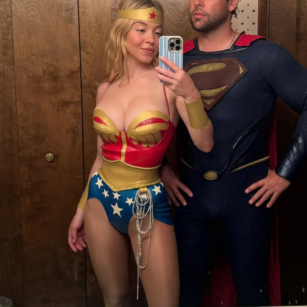 Sydney Sweeney dressed as Wonder Woman taking a mirror selfie next to Scooter Braun dressed as Superman.