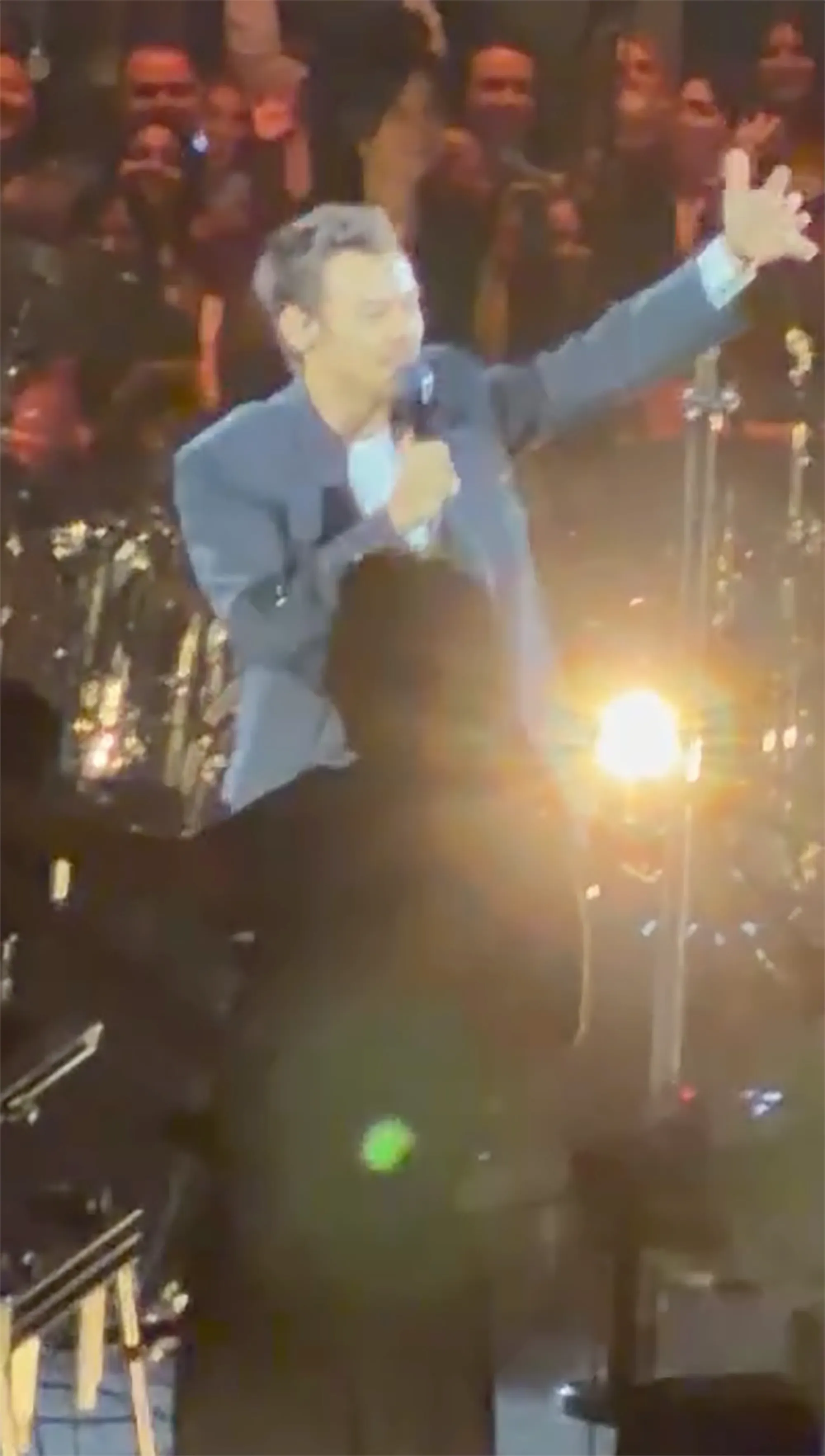 Harry Styles performing on stage.