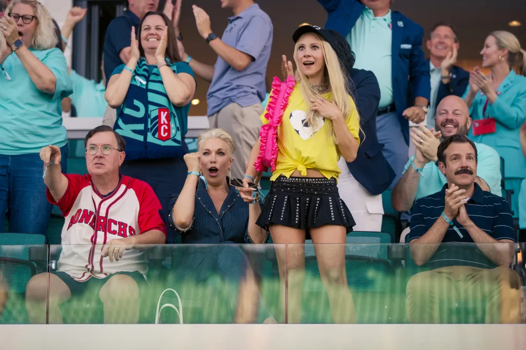 Fans at a sporting event, with Ted Lasso in the foreground.