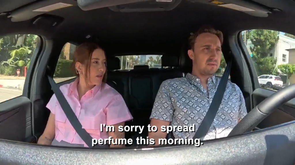 A man and a woman in a car, with the caption