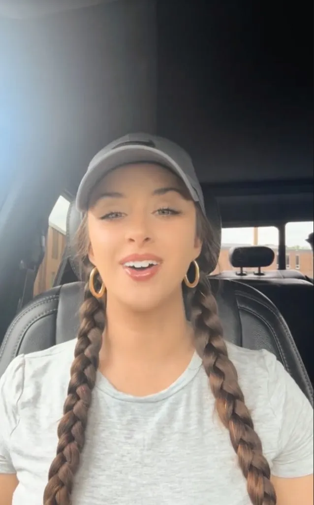 TikTok food critic Christina Hart, wearing a cap and hoop earrings, speaking into the camera.