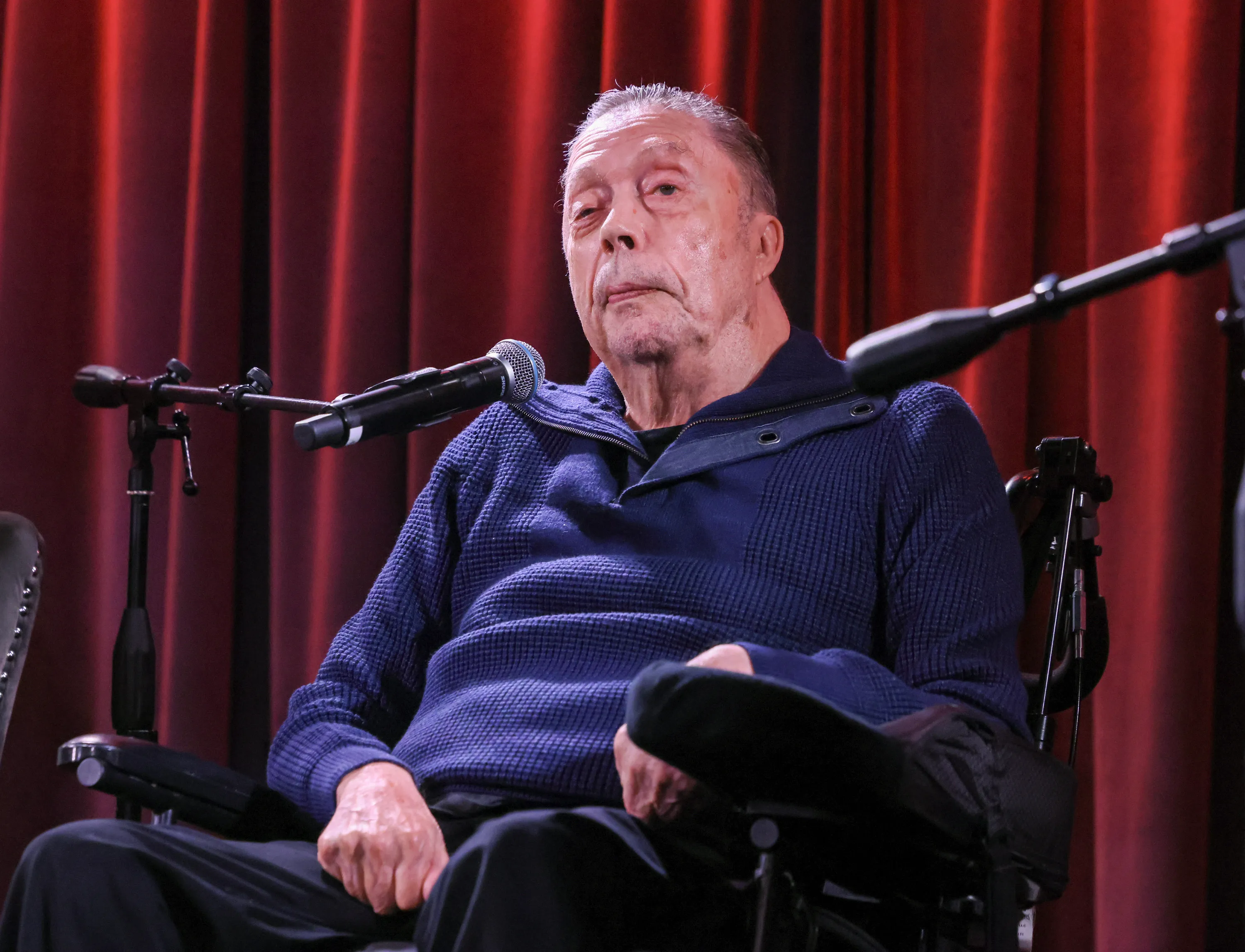 Tim Curry in a wheelchair speaks at the GRAMMY Museum.