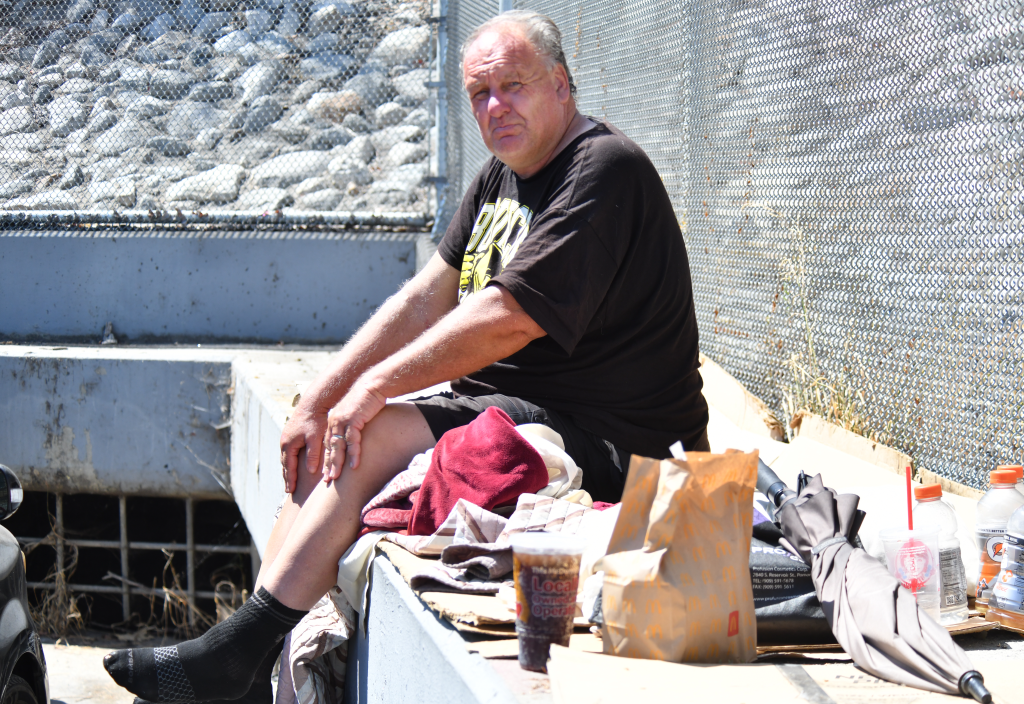Tim Roller, a homeless man, sits outdoors at his regular encampment spot in Los Angeles.