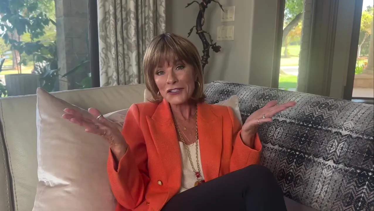 QVC host Toni Brattin sitting on a couch and gesturing with her hands.