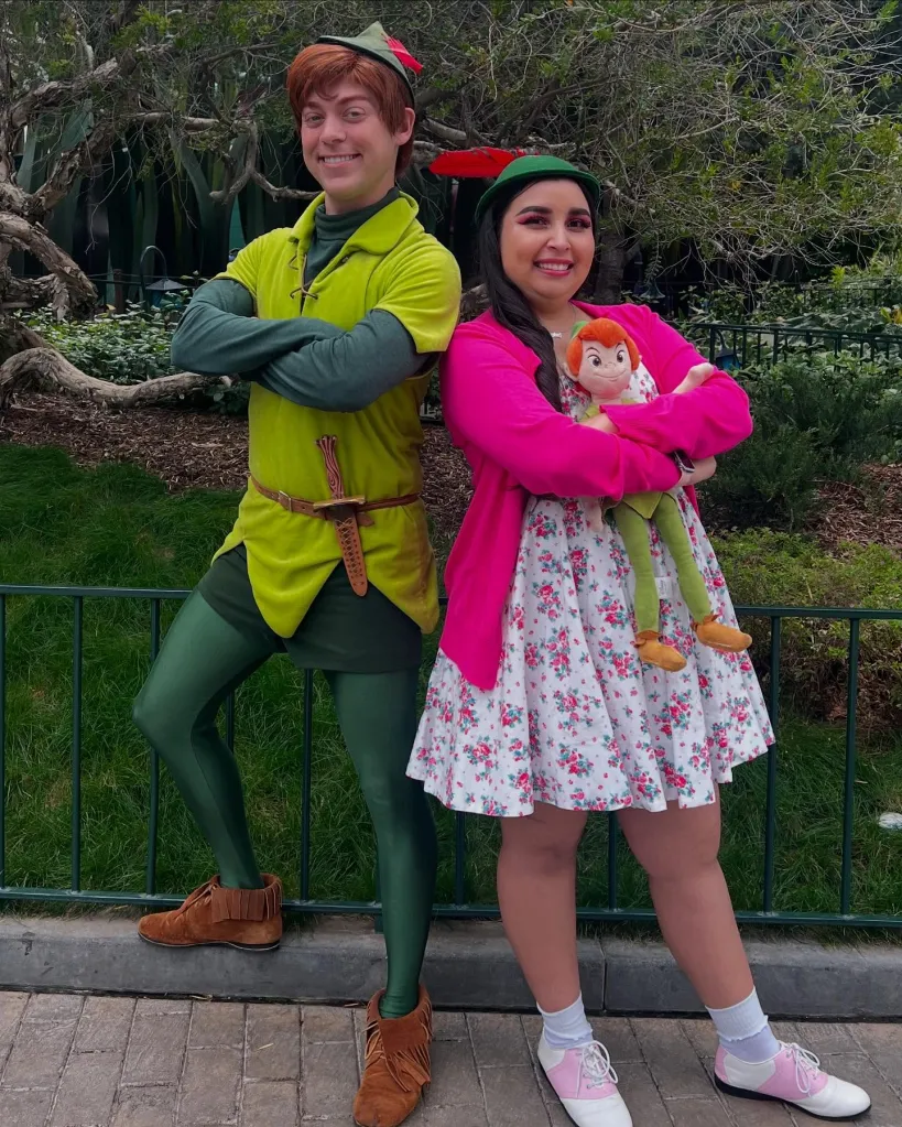Toni Kulusich, holding a Peter Pan doll, posing next to a person dressed as Peter Pan.
