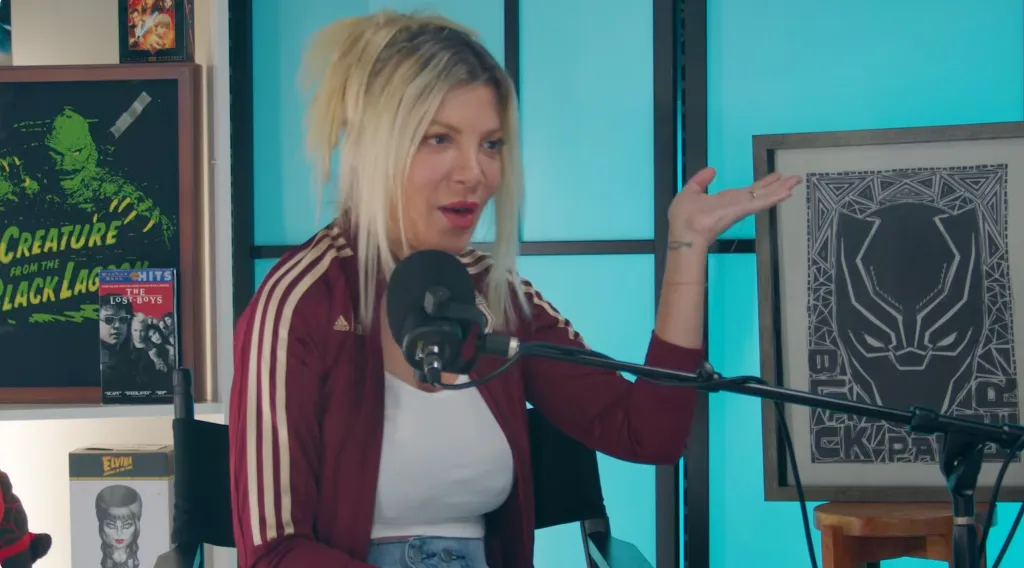 Tori Spelling speaking into a microphone.