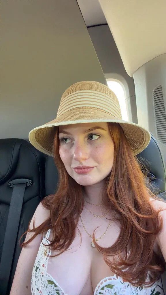 Grace Ryan wearing a straw hat while seated.