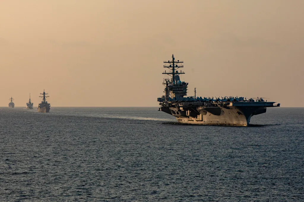 A carrier strike group transits the Strait of Hormuz.