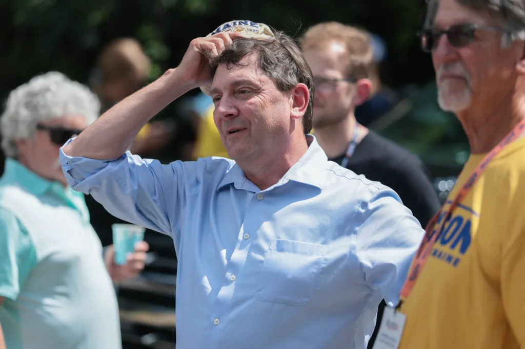 Troy Jackson adjusting his hat while greeting people.