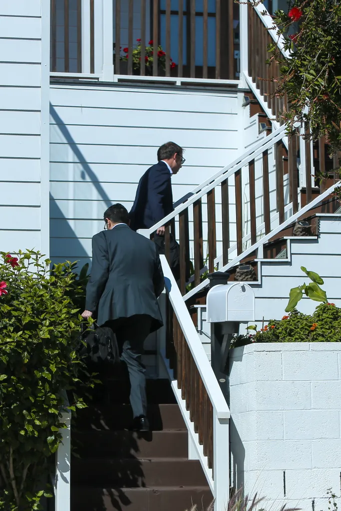 Two men in suits walk up a set of stairs.