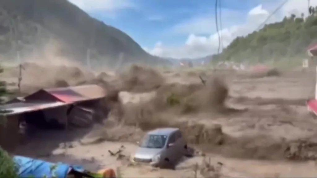 Flash flood in Nepal sweeping away a car and buildings.