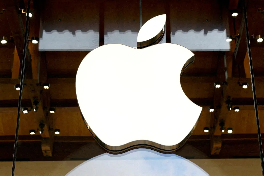 An illuminated Apple logo displayed in a store window.