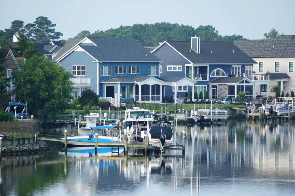View of luxury waterfront homes with boat lifts by the bay in Rehoboth Beach, Delaware.