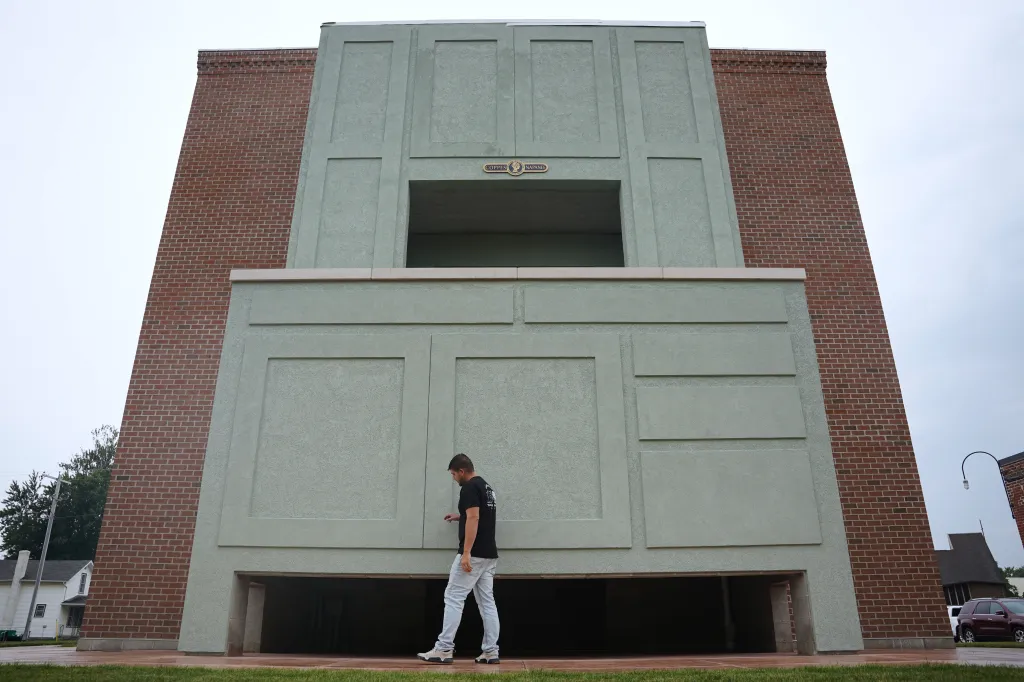 Coppes Napanee owner Wesley Mast walks past the 30 foot replica of a Hoosier cabinet in Nappanee, Ind., on Aug. 6, 2026.
