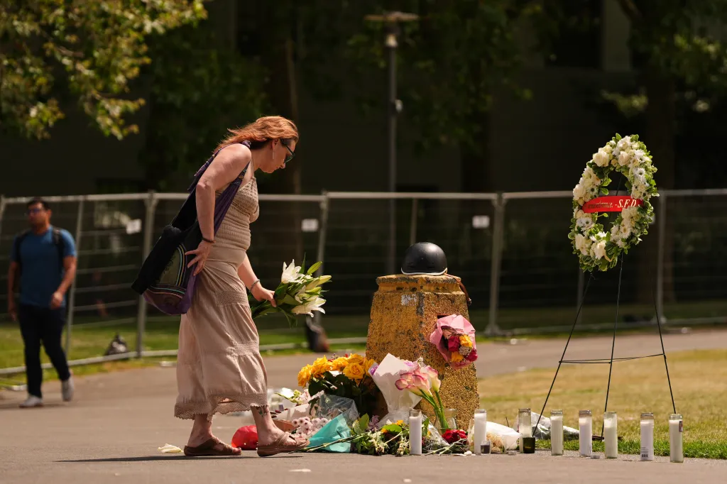 A woman places flowers at a memorial for victims of a shooting at Seattle Center.