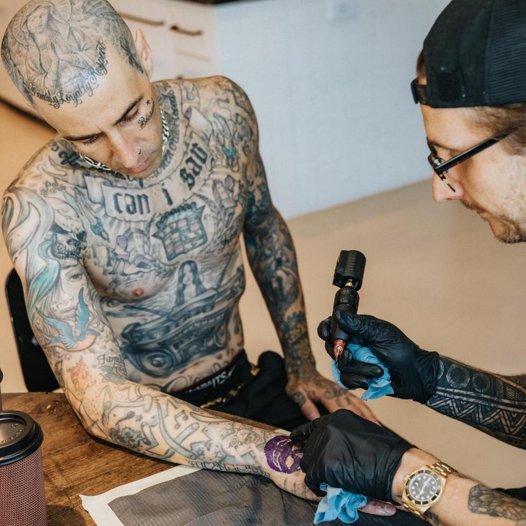 Travis Barker getting a tattoo on his forearm.