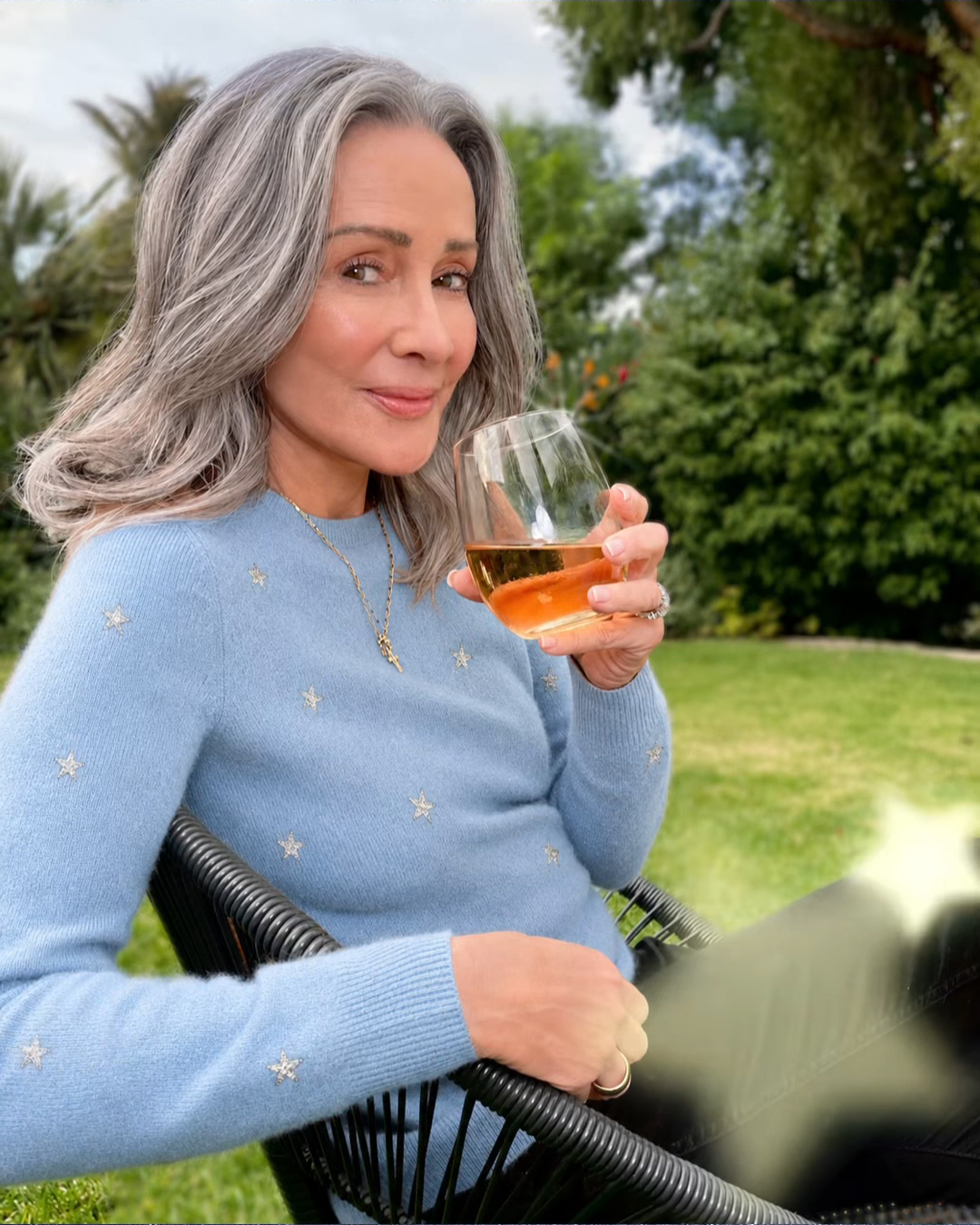 Patricia Heaton smiling and holding a glass of non-alcoholic wine.