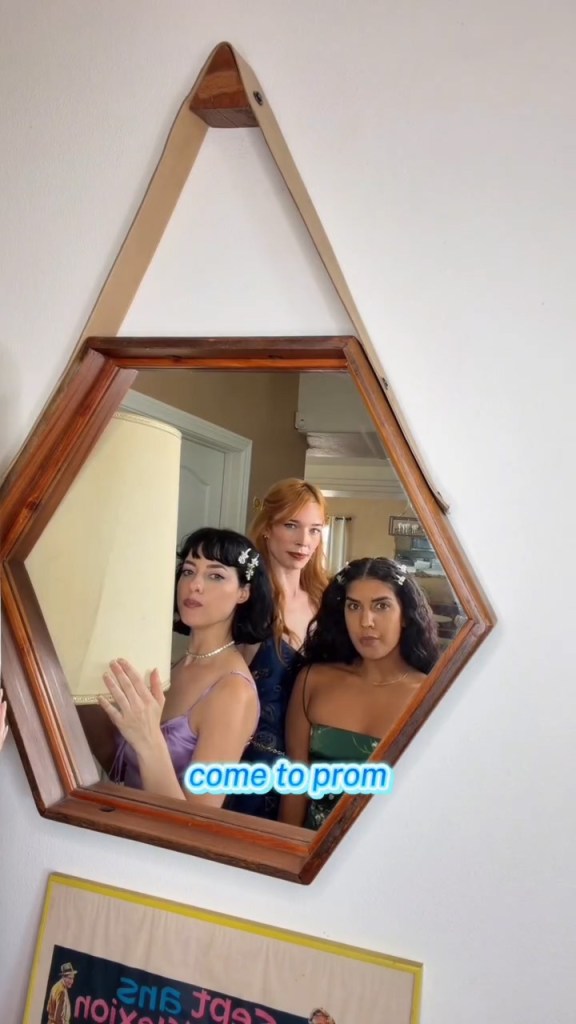 Three women reflected in a hexagonal mirror, with a blue text overlay