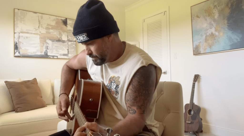 Johnny Bananas playing an acoustic guitar.