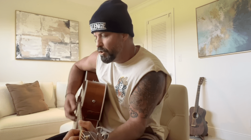 Johnny Bananas playing an acoustic guitar.